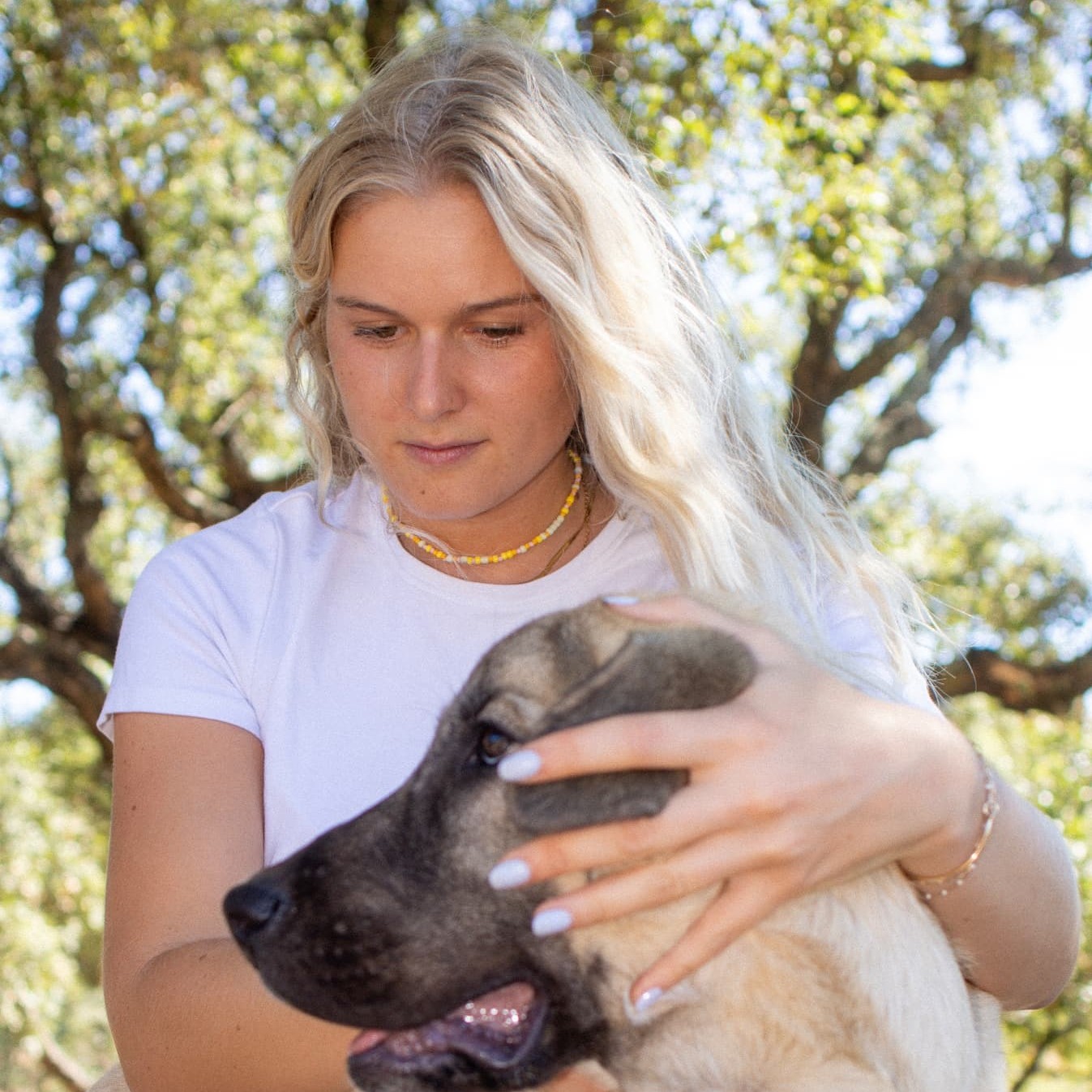 Carla assise avec un chiot beige sur les genoux
